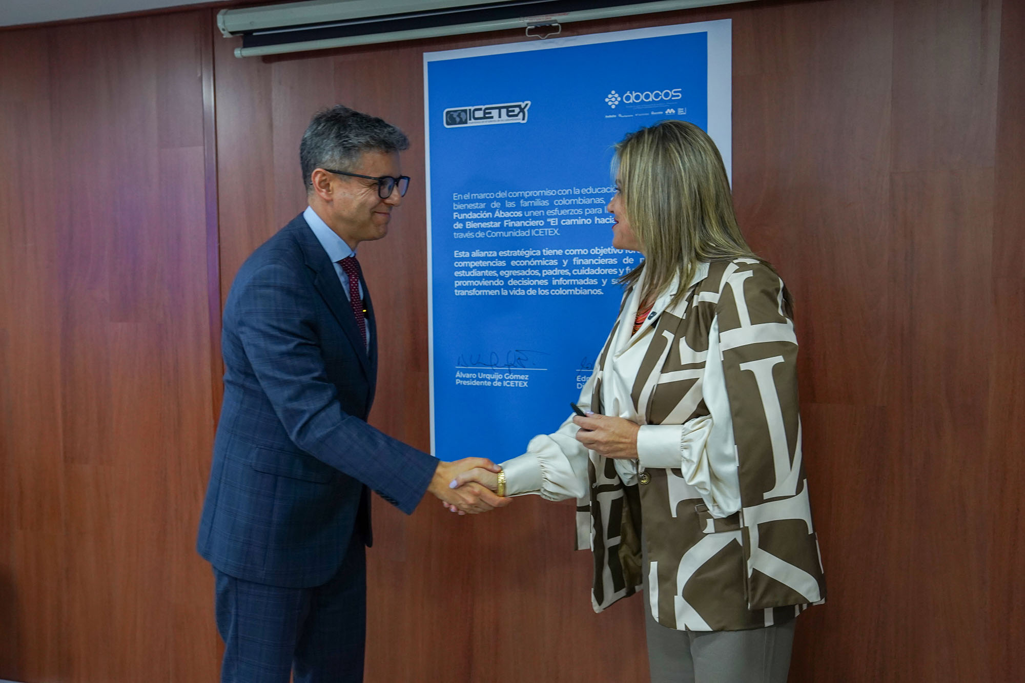 Edna Bonilla, directora ejecutiva de la Fundación Ábacos y Álvaro Urquijo Gómez, presidente de Icetex, estrechan la mano al firmar el acuerdo.